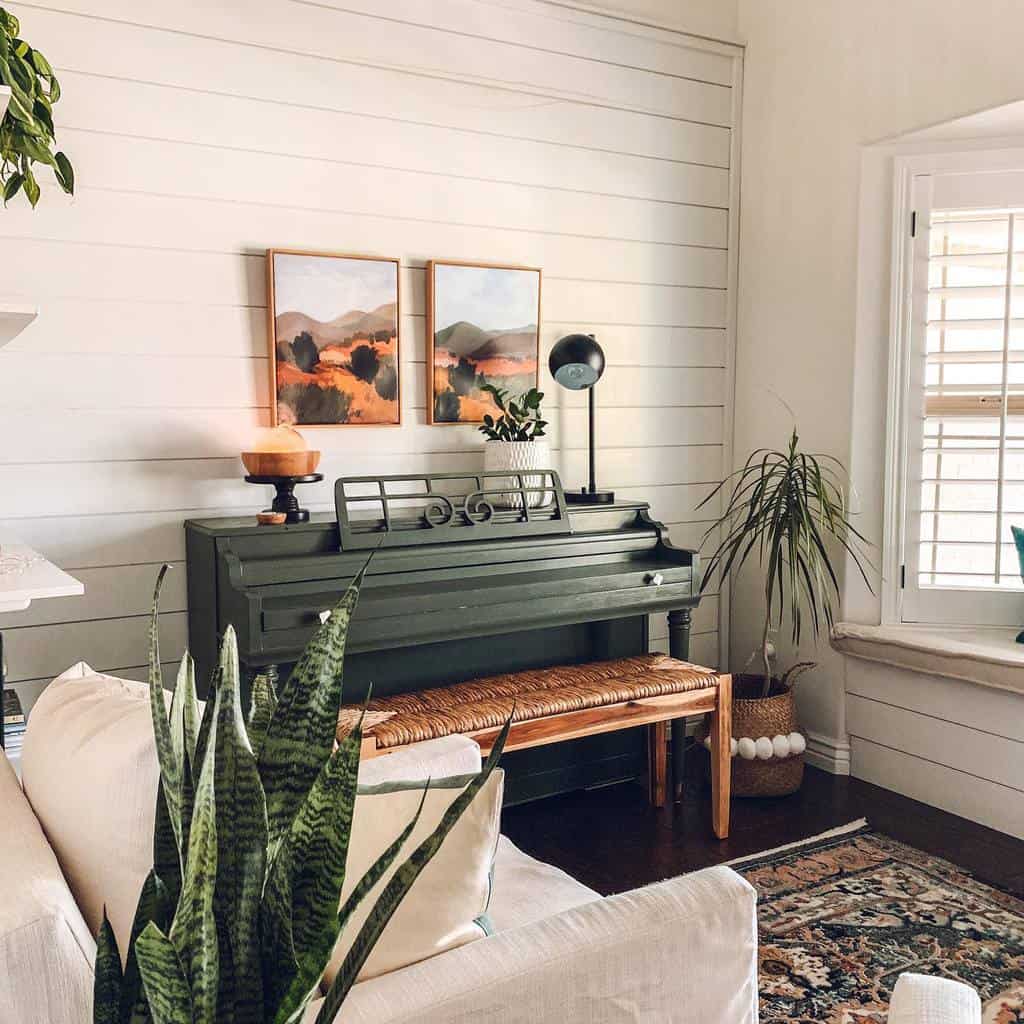 Cozy farmhouse-style music room with a vintage green piano, warm decor, natural wood accents, indoor plants, and soft neutral tones