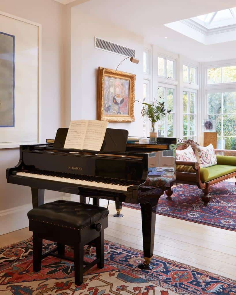 Elegant music room with a Kawai grand piano, a vintage rug, natural light from large windows, and classic decor with artistic touches