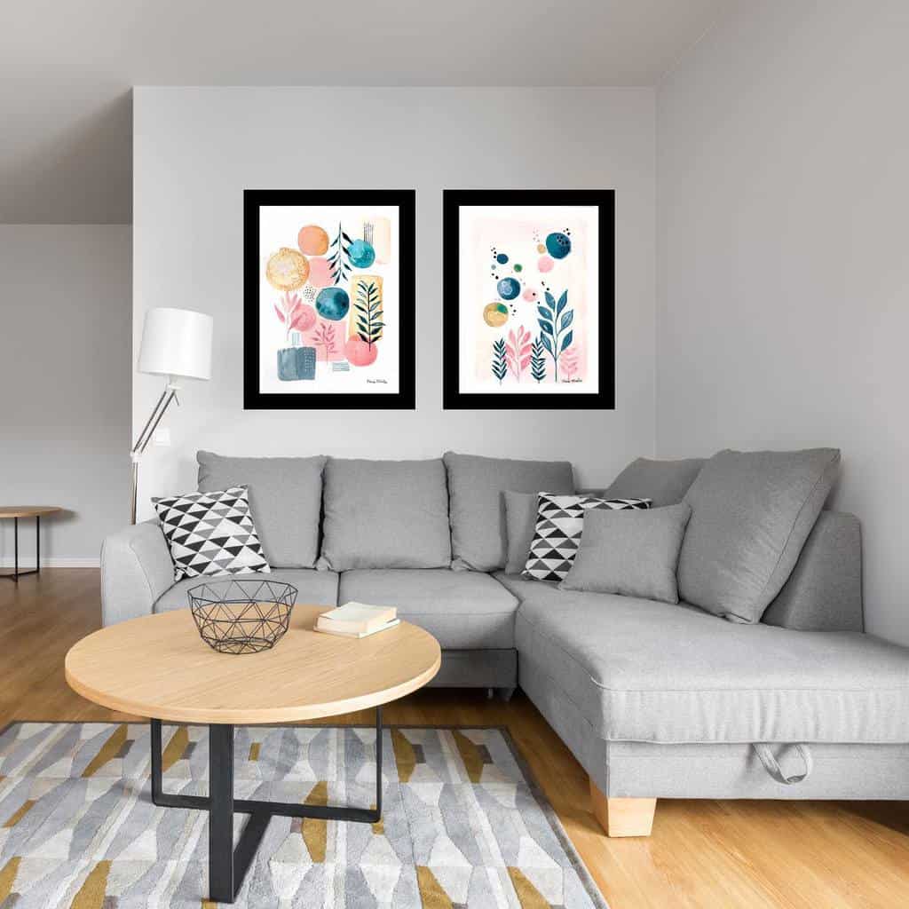 Modern round wooden coffee table with black metal legs, styled with a geometric wire basket and book, set in a minimalist living room