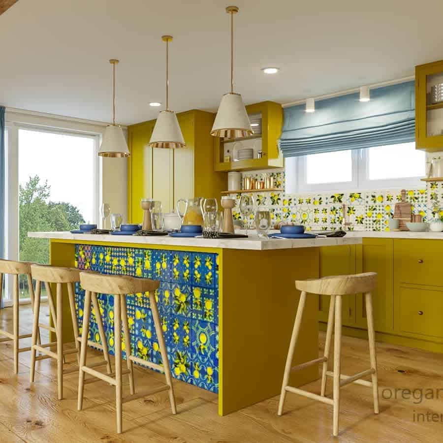 A brightly lit kitchen with yellow cabinets, a central island with colorful tiles, and wooden stools, featuring modern pendant lights.