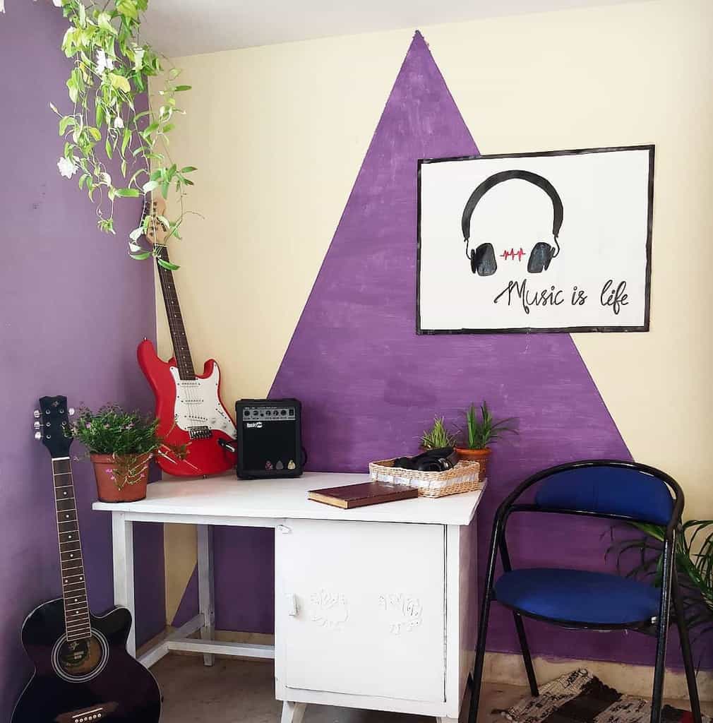 Creative music corner with a bold purple accent wall, wall-mounted guitars, a small amplifier, potted plants, and a "Music is Life" artwork