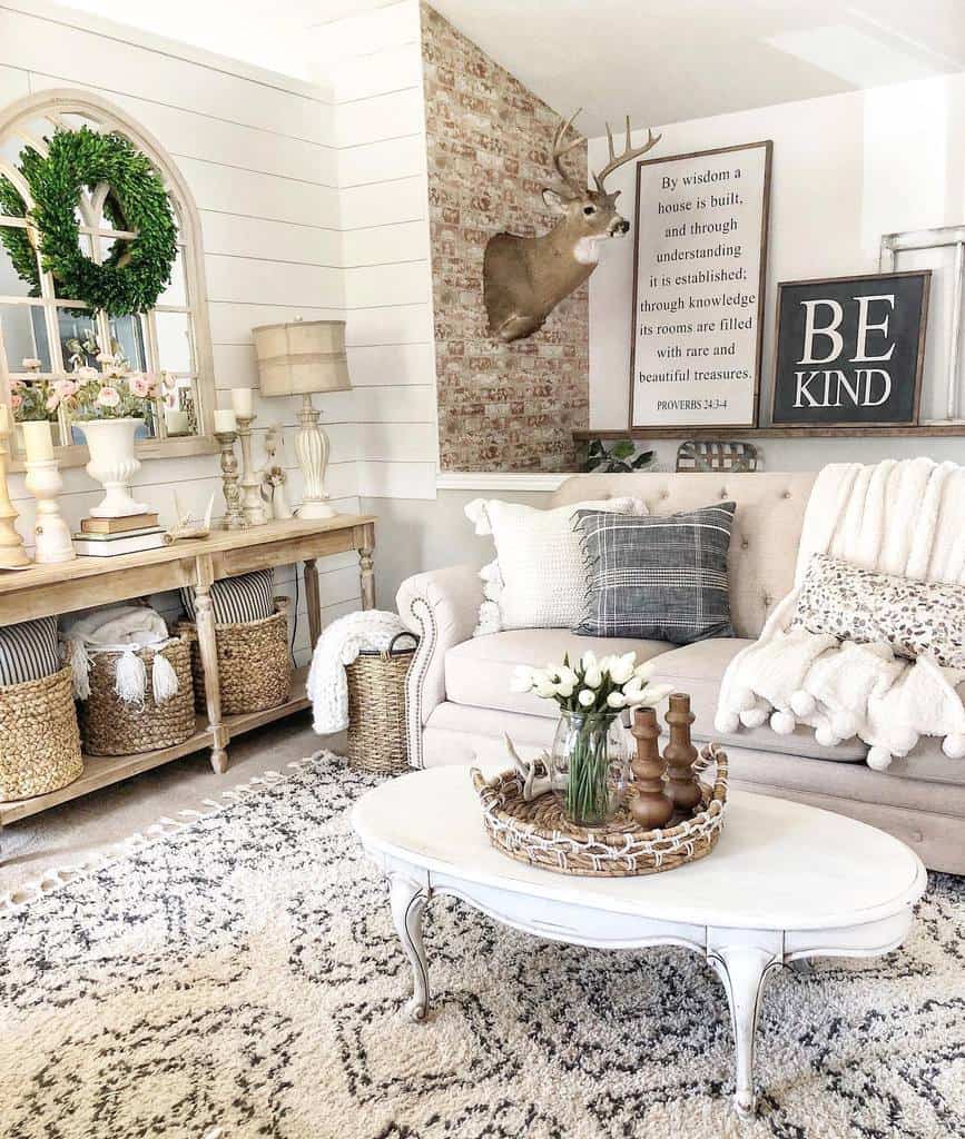 Vintage white oval coffee table with curved legs, styled with a woven tray, wooden candlesticks, and fresh flowers, set in a cozy farmhouse living room