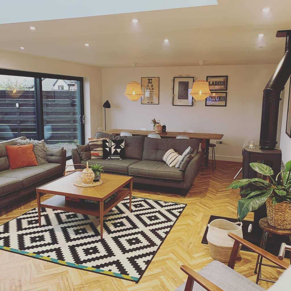 Mid-century modern wooden coffee table with a lower shelf, styled with a woven lantern and plant, set in a cozy open-plan living room with warm tones