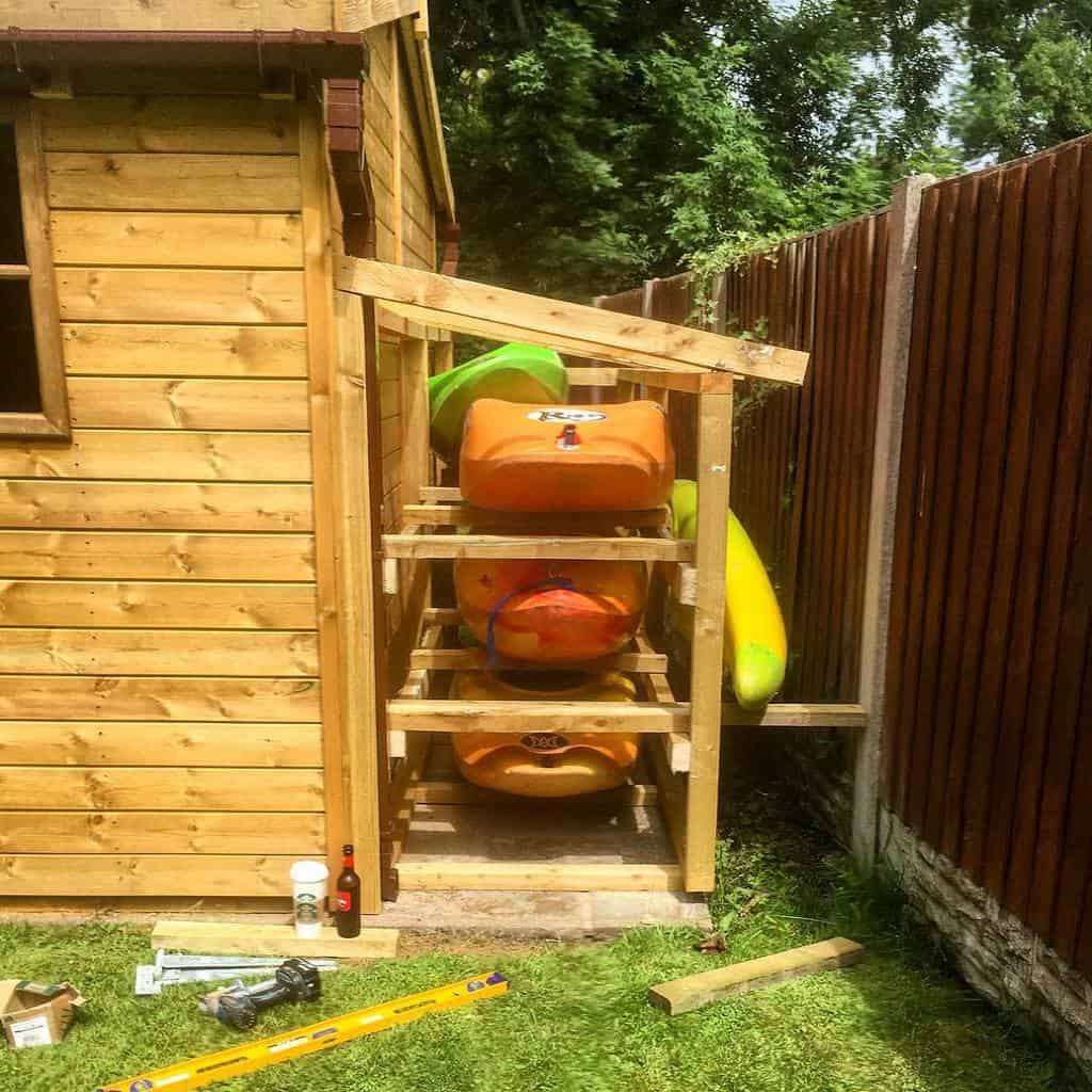 Orange kayaks on wooden storage rack