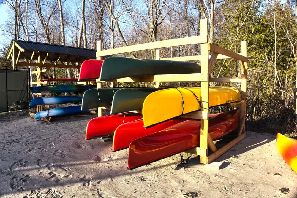 Colorful kayaks on wooden storage rack