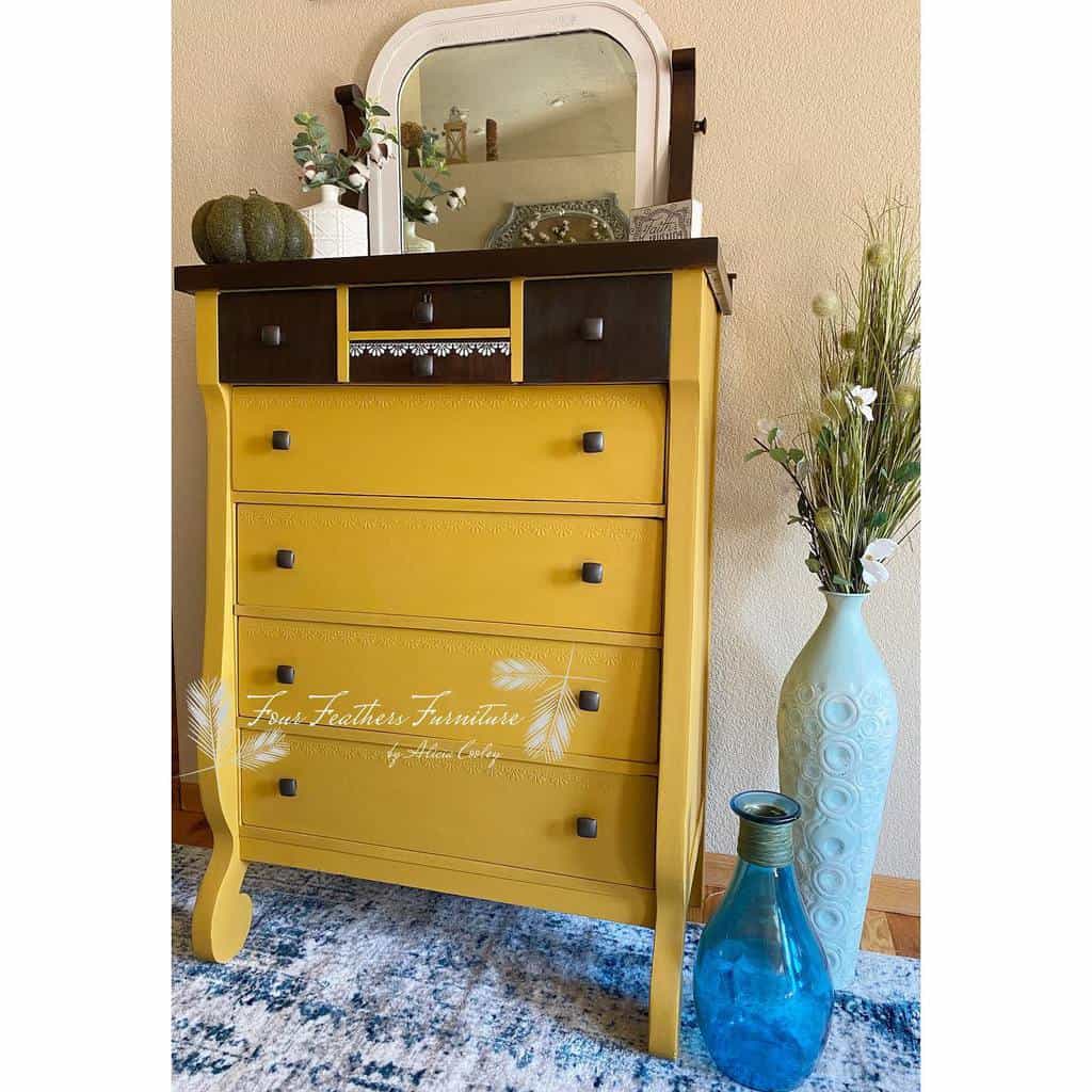 Vintage wooden dresser painted mustard yellow and dark brown with chalk paint, featuring a mirror and decorative accents