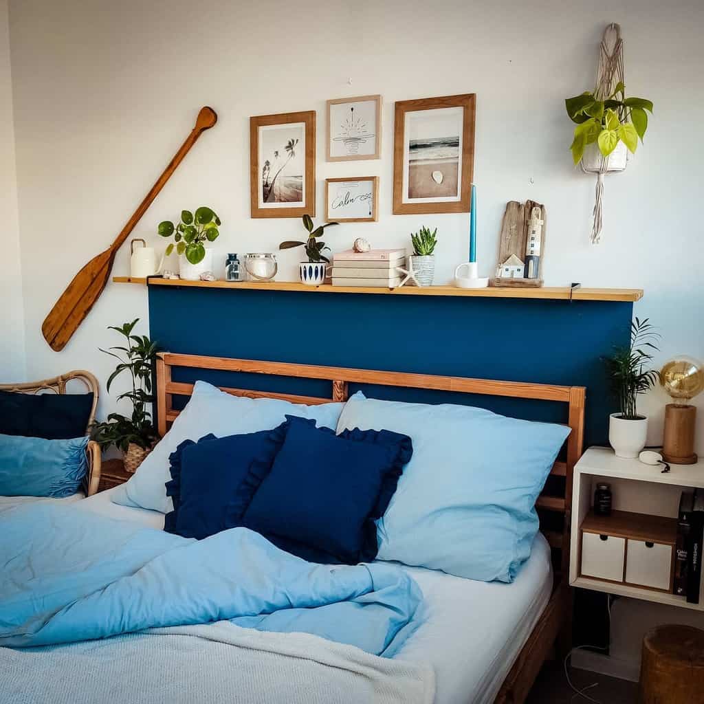 Coastal bedroom with a navy accent wall, wooden bed frame, and nautical decor, featuring ocean-inspired artwork and natural textures