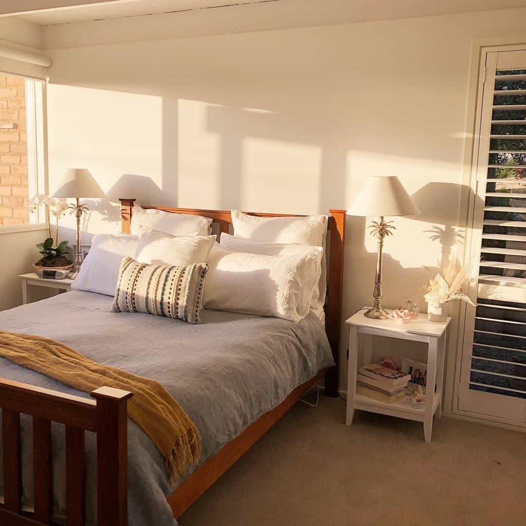 Sunlit coastal bedroom with wooden furniture, soft linens, and tropical-inspired decor, creating a warm and airy beachside retreat