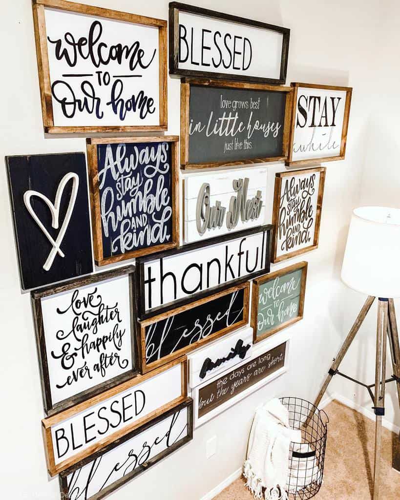 Wall with framed inspirational quotes in various fonts, including "welcome to our home" and "blessed," next to a floor lamp and basket