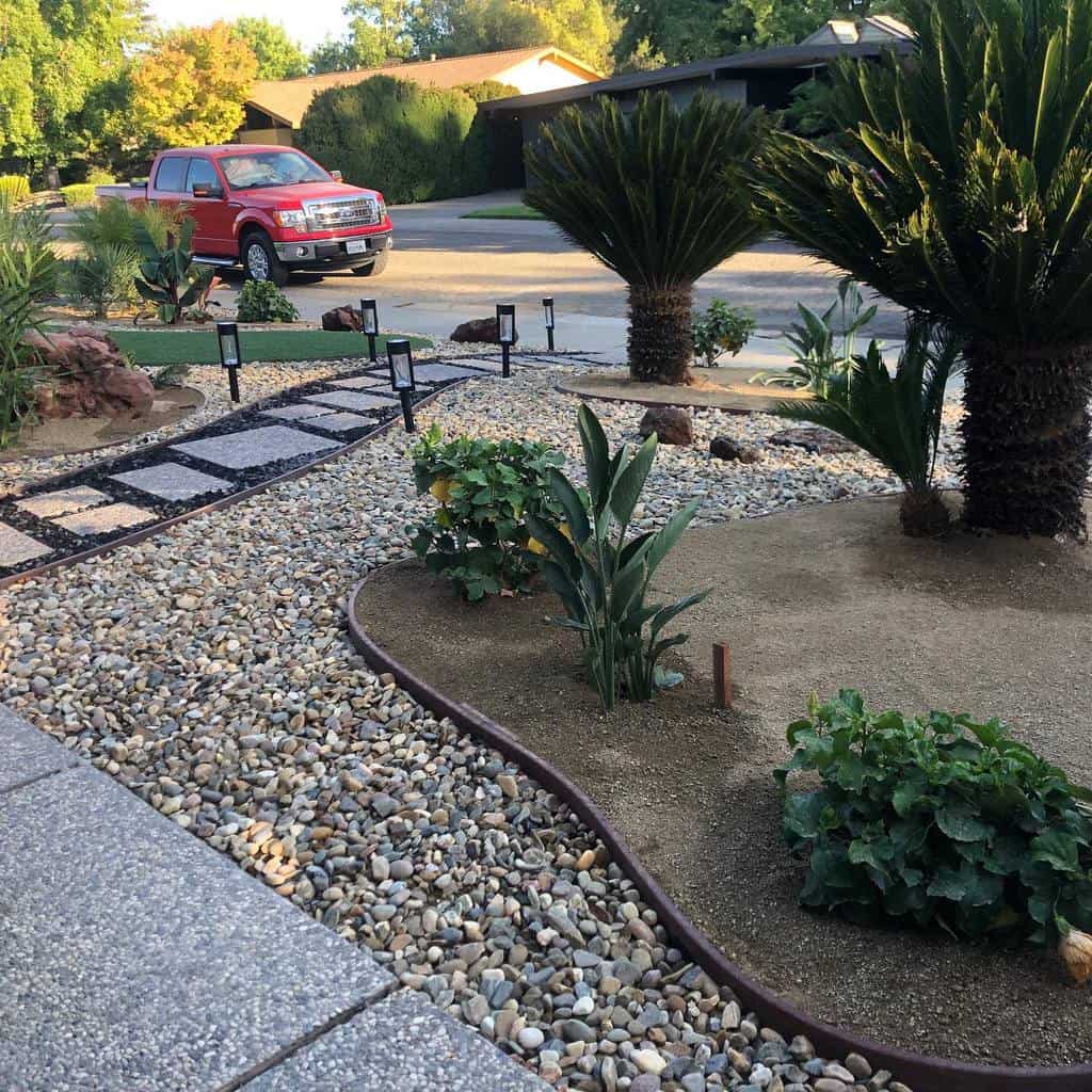 Modern front yard xeriscape with gravel, stepping stone pathway, drought-tolerant plants, palm trees, and solar-powered garden lights