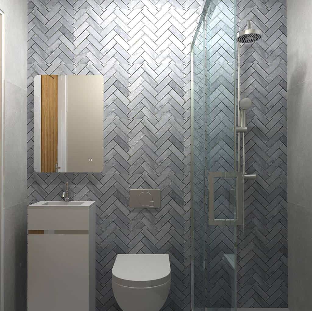 Wet room with herringbone tile wall, a mirror above a compact sink, toilet, and glass-enclosed shower