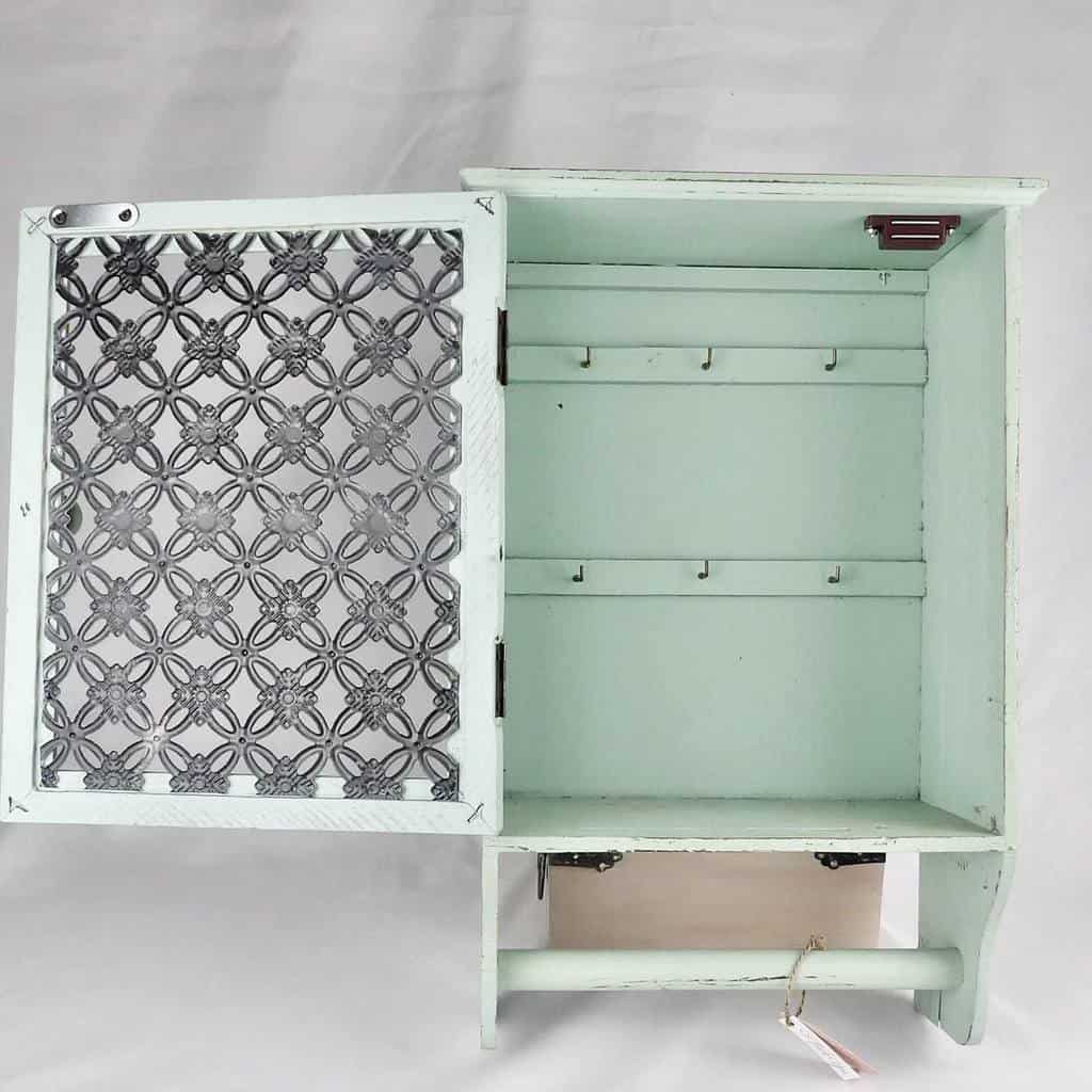 Light mint green chalk-painted wall cabinet with decorative metal mesh door and multiple hooks for hanging keys or accessories