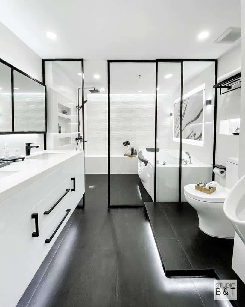 Sleek monochrome wet room with black-framed glass dividers, a floating vanity, and a spa-like bathtub for a modern, minimalist look