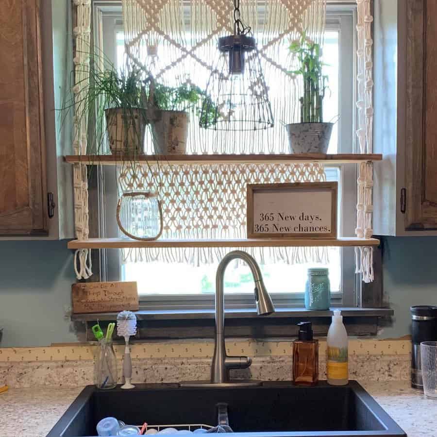 Wooden open shelves with macrame accents hold potted plants and decor, creating a cozy boho-style kitchen window display above the sink