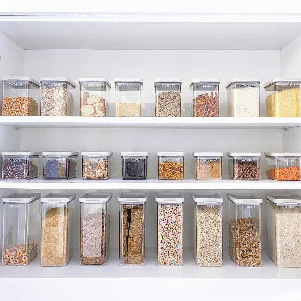 Neatly organized pantry shelves with clear containers filled with various dry goods, cereals, and snacks