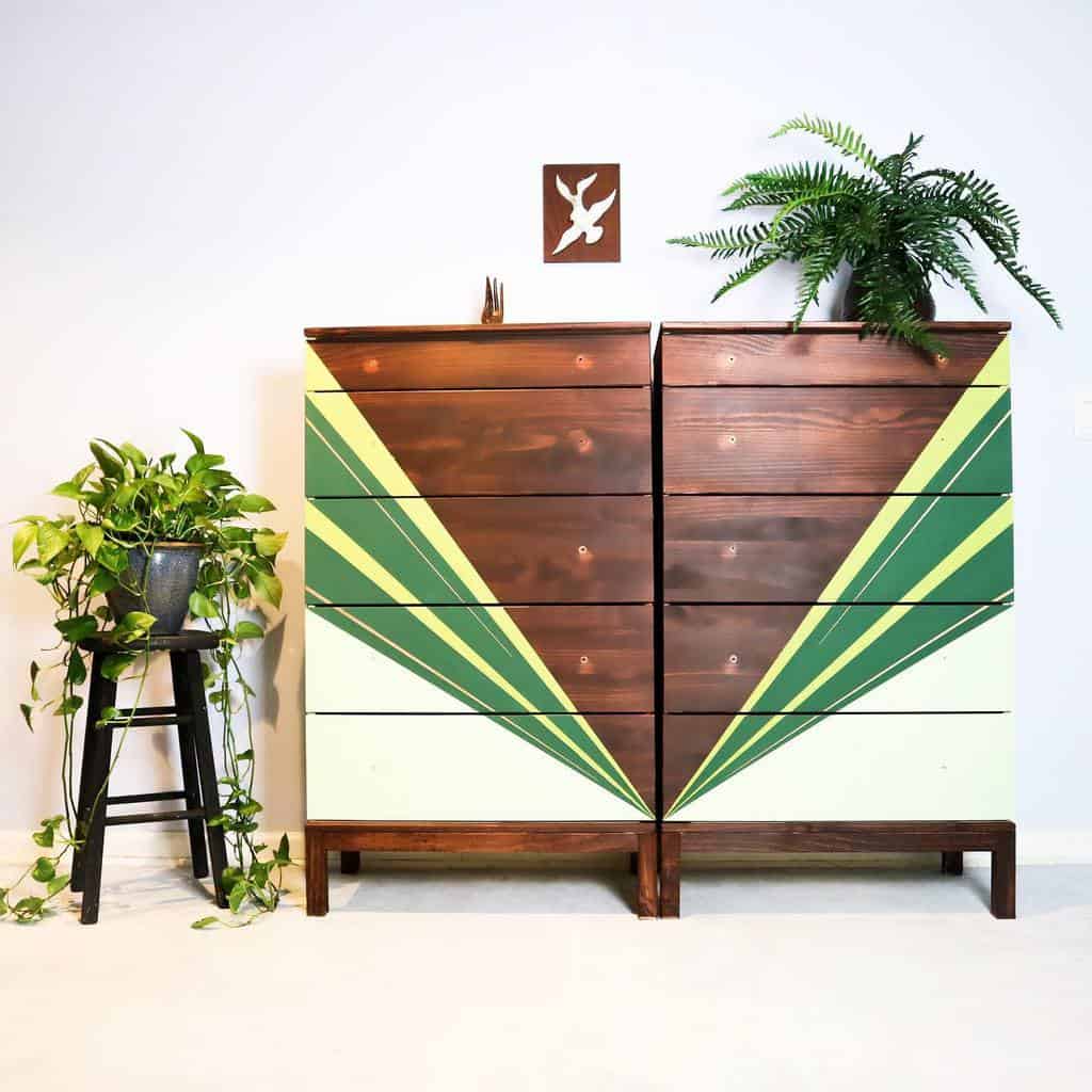 Mid-century modern dressers with a geometric green and yellow chalk-painted design, paired with rich wood tones and styled with lush plants