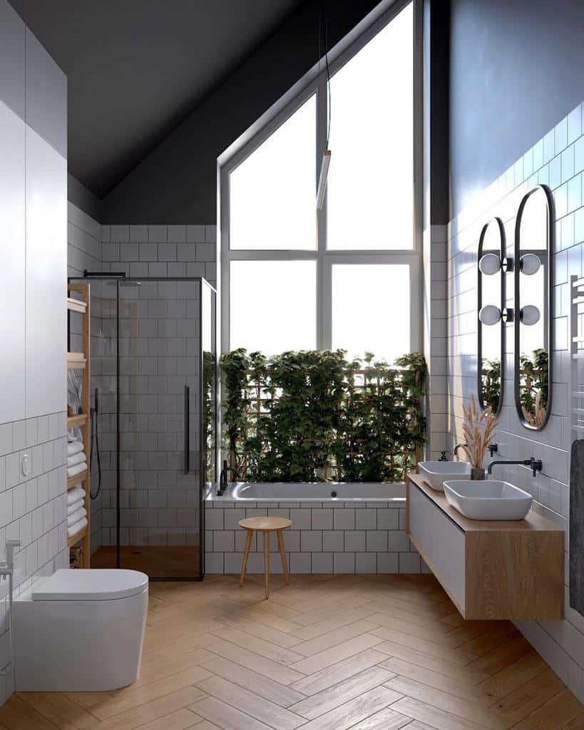 Modern wet room with large window, glass shower, freestanding tub, wood herringbone floor, and dual sinks on a floating vanity