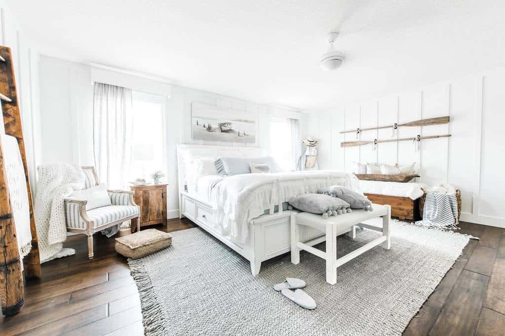 Bright coastal bedroom with white wooden furniture, soft neutral tones, and rustic accents, creating a serene and airy beach-inspired retreat