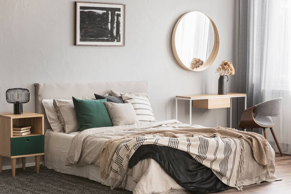 bedroom with elegant round mirror