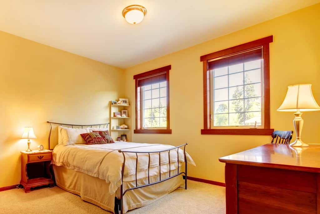 pale yellow color bedroom with cherry furniture