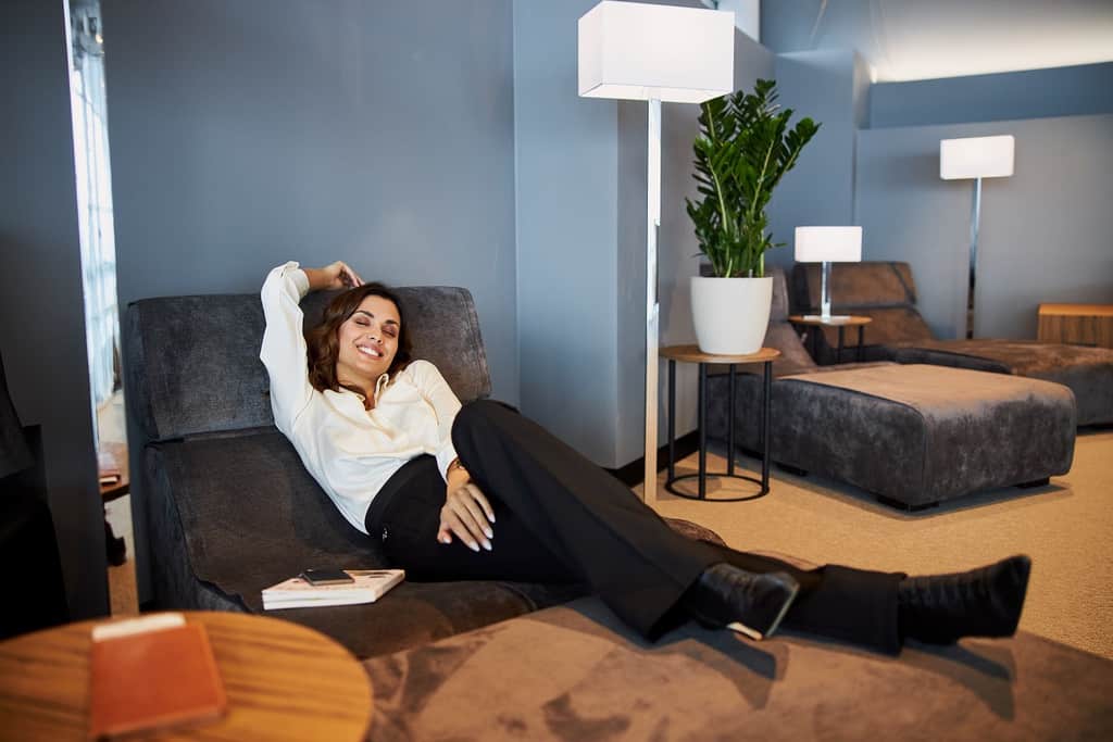 woman smiling while lying on comfortable daybed