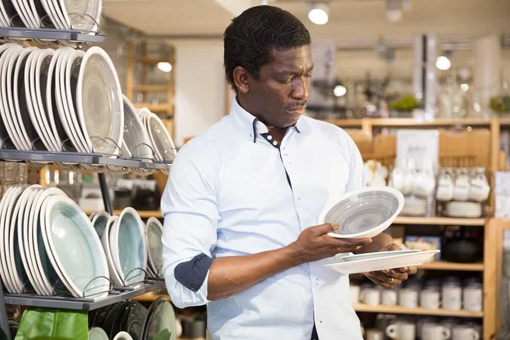 african adult choosing plates for wall