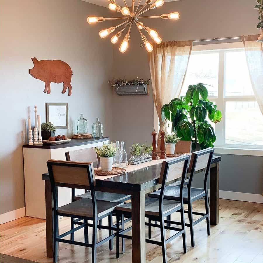 Farmhouse-style dining room with a rustic wood table, greenery centerpiece, glass bottles, and warm lighting for a cozy ambiance