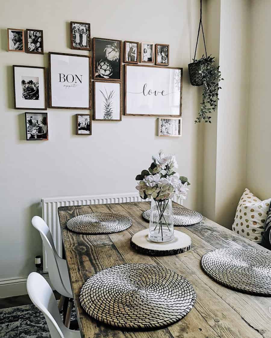 A dining area with a wooden table, wicker placemats, and a floral centerpiece; gallery wall with various framed pictures and decor