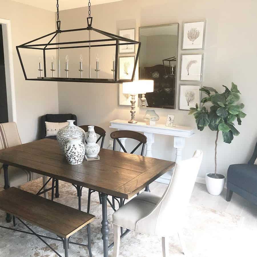 Modern farmhouse dining room with a wood table, ceramic vase centerpiece, black metal chandelier, and neutral-toned decor