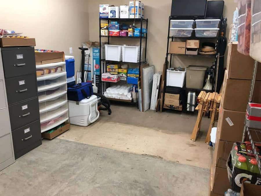 Storage room with shelves holding various items, including boxes, paper products, and a cooler; filing cabinets are on the left