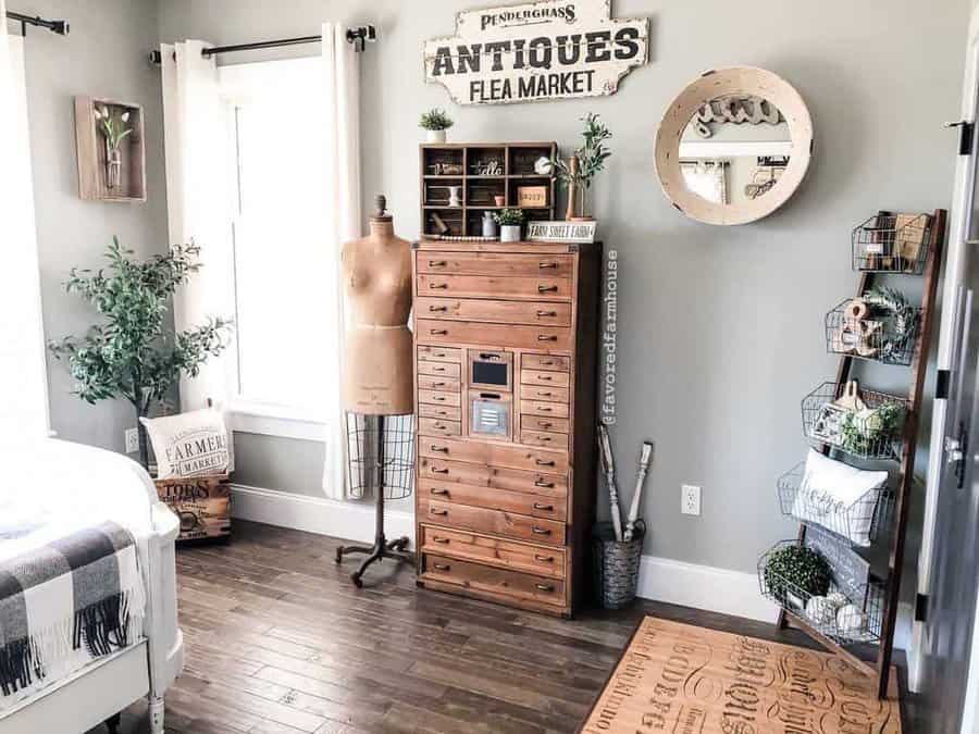 Vintage farmhouse bedroom with a tall wooden storage cabinet, wire basket shelves, and rustic decor for a charming and organized space