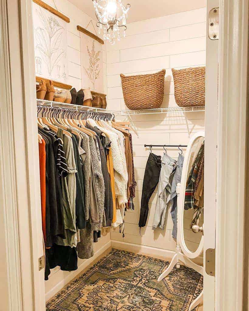 Cozy walk-in closet with clothes on hangers, wicker baskets on a shelf, and a standing mirror; vintage rug on the floor