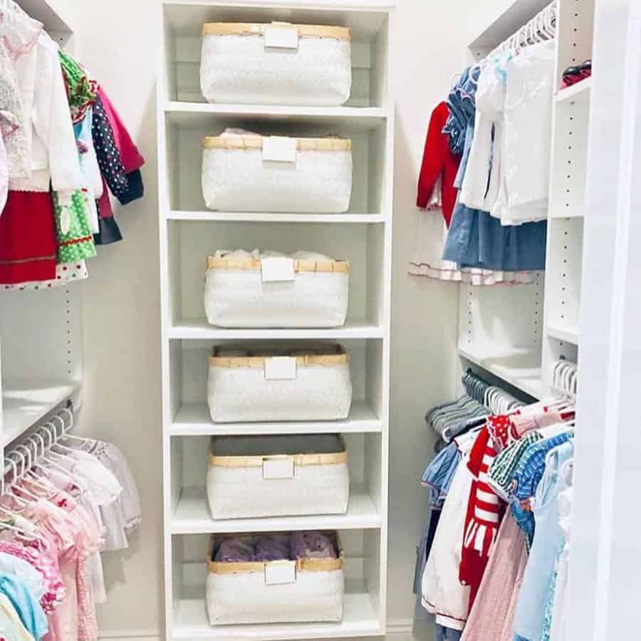 Organized closet with baskets on shelves and colorful clothes hanging on both sides