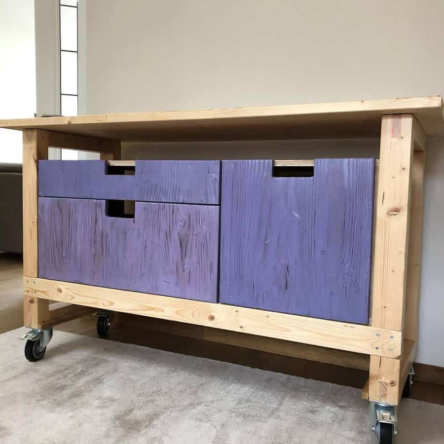 DIY wooden workbench with purple storage drawers on caster wheels, combining rustic charm with functionality for workspace organization