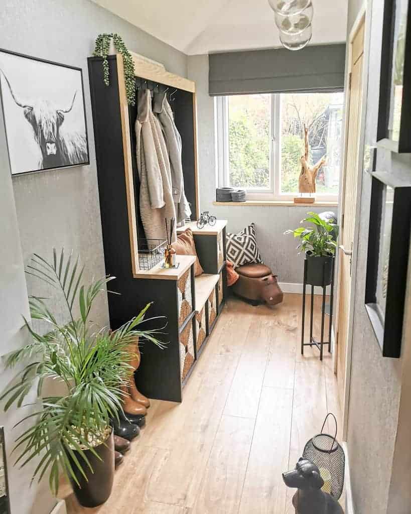 Stylish mudroom with a built-in coat rack, bench seating, woven storage baskets, and greenery for a cozy and organized entryway