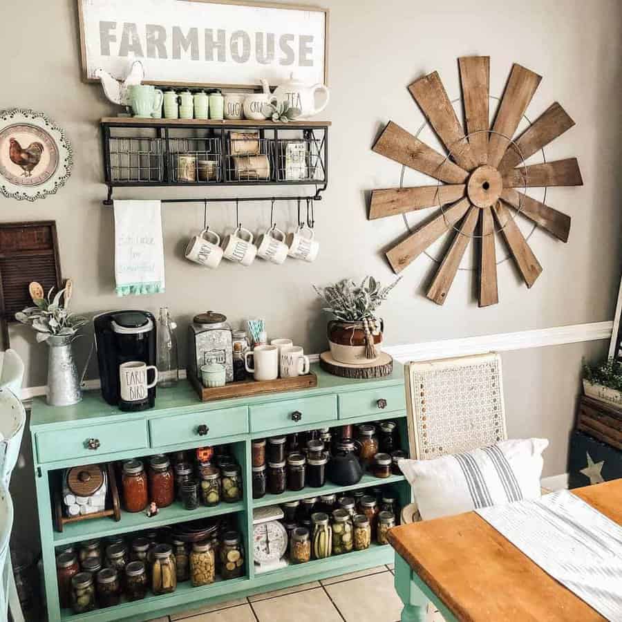 Cozy farmhouse kitchen with mint-colored cabinet, jars, mugs, rustic decor, wooden windmill wall art, and a farmhouse sign