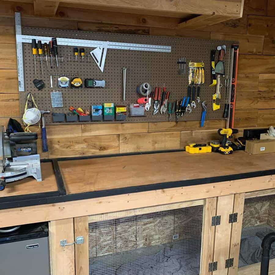 A tidy wooden workbench with tools neatly organized on a pegboard above, including screwdrivers, pliers, and measuring tape