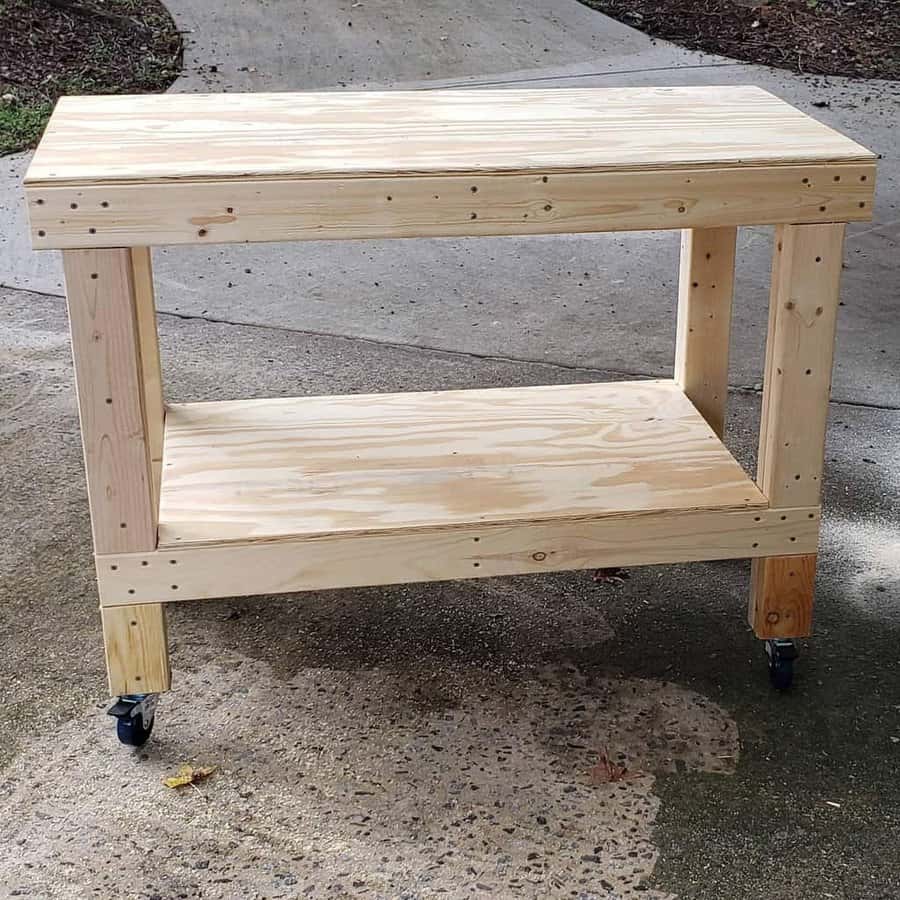 Wooden workbench on caster wheels, placed outdoors on a concrete surface