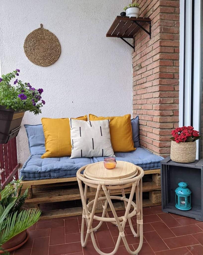 Cozy pallet sofa with layered cushions and warm-toned pillows, creating a charming boho-style balcony retreat with rustic and modern accents