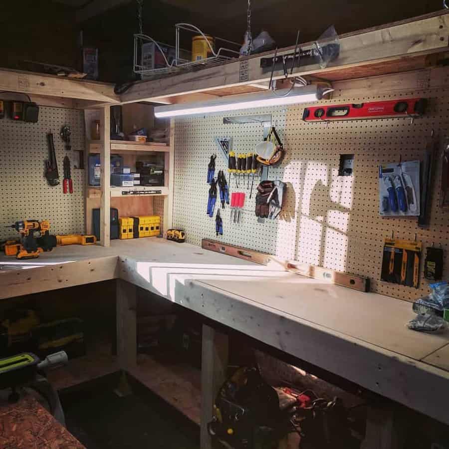 A well-organized woodworking bench with tools hanging on pegboards, a bright overhead light, and shelves with supplies