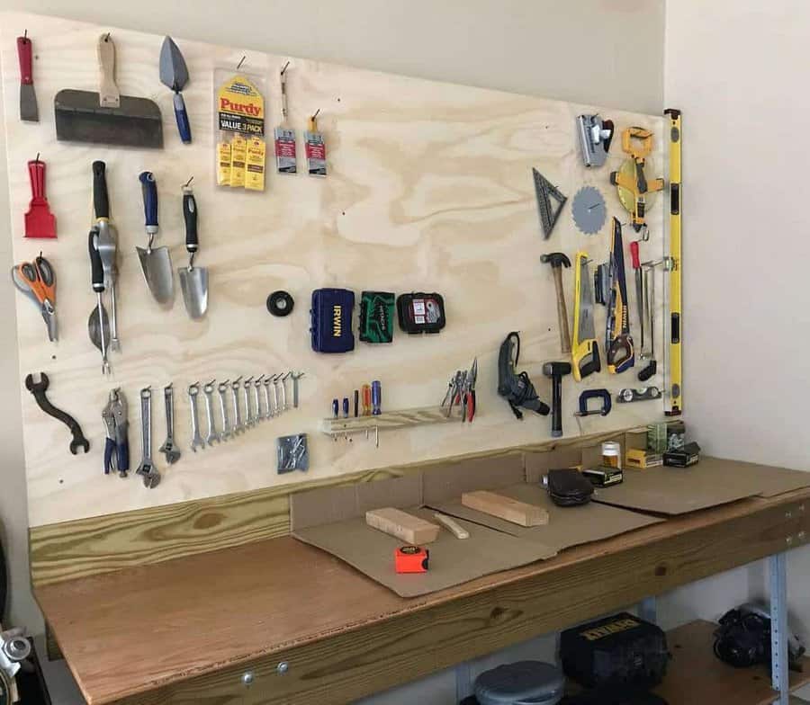 A tidy workbench with tools like wrenches, hammers, and screwdrivers organized on a pegboard, measuring tapes and levels are also visible