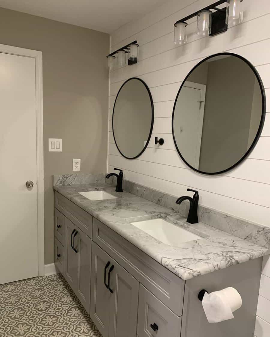 Dual vanity bathroom with round mirrors and patterned floor