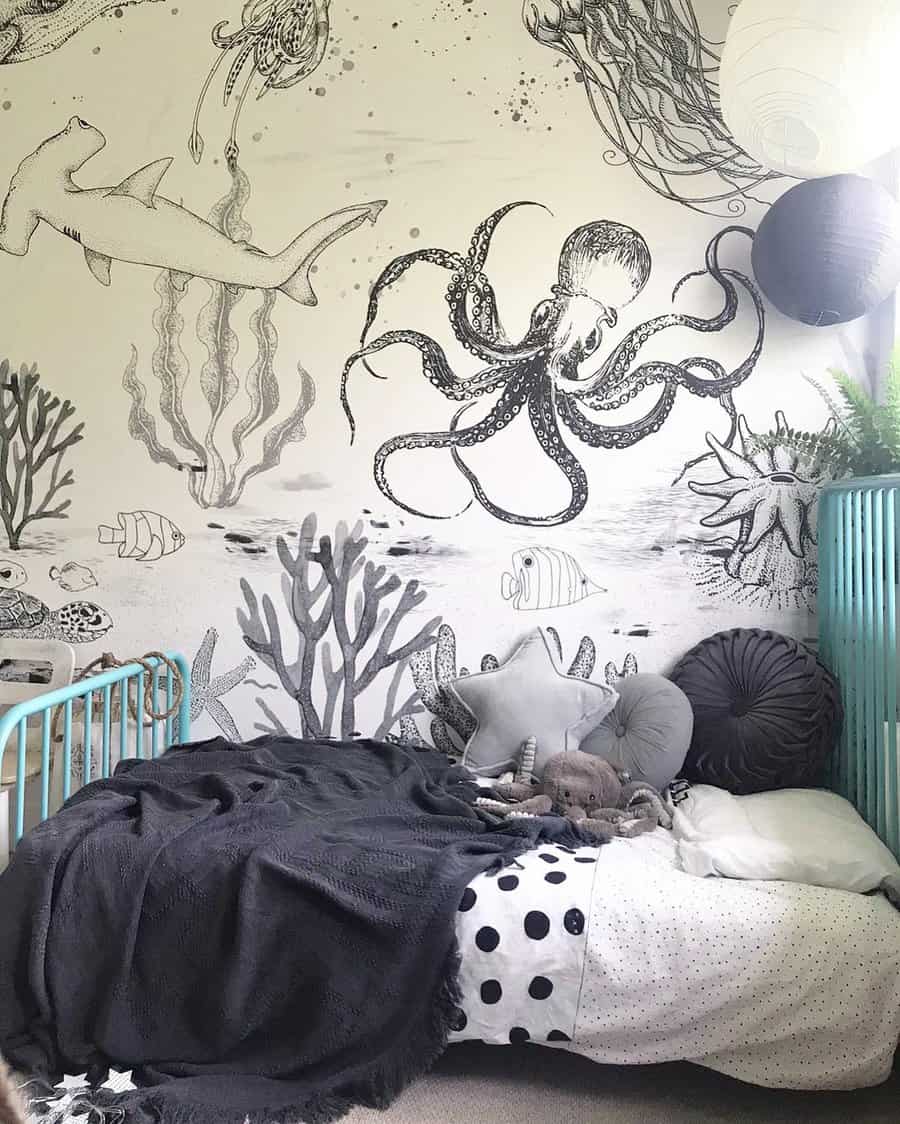 Child's room with an ocean-themed mural featuring sea creatures; a turquoise bed with gray and white bedding is in the foreground