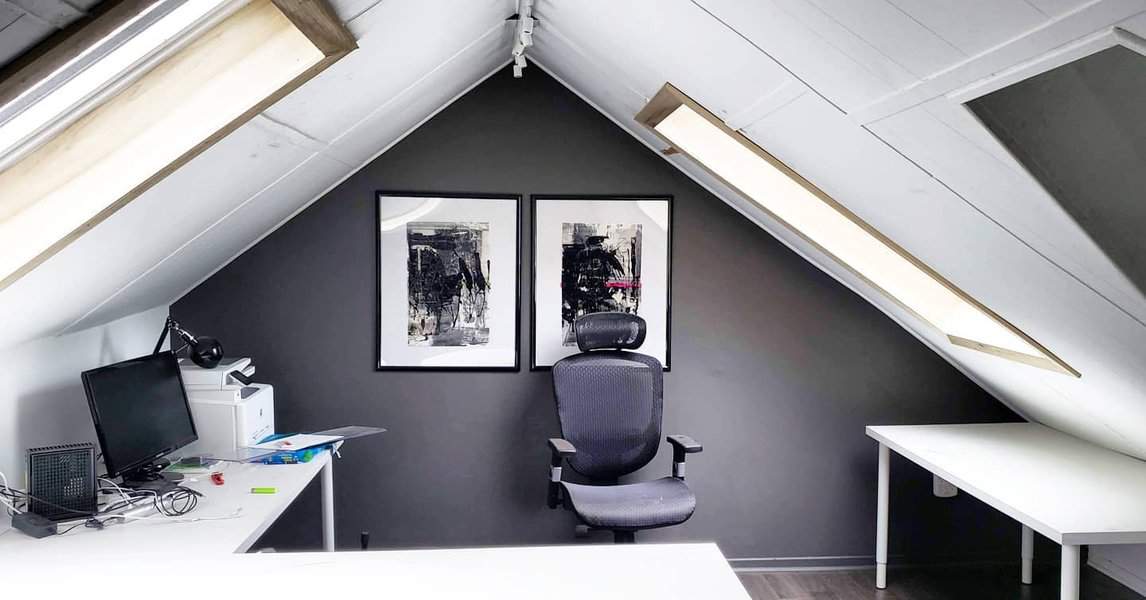 Attic home office with skylights and monochrome art