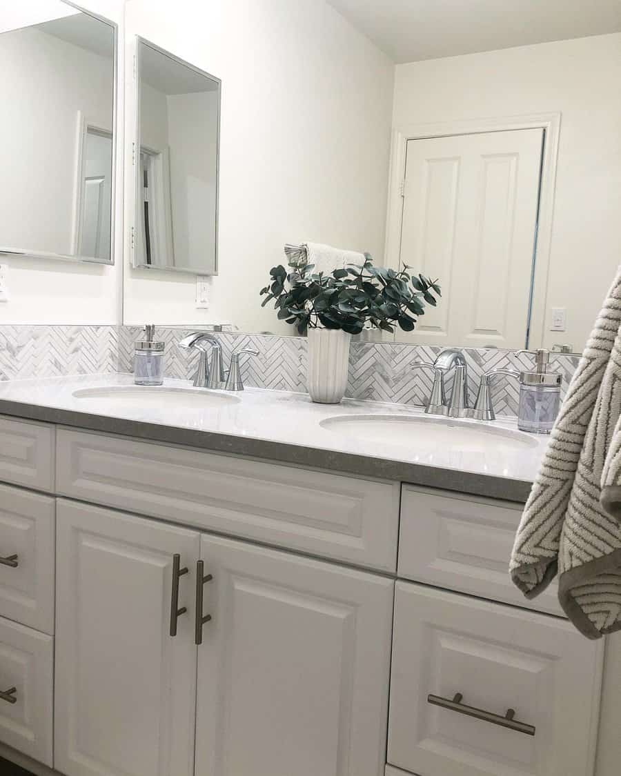 Bathroom sink with herringbone tile backsplash