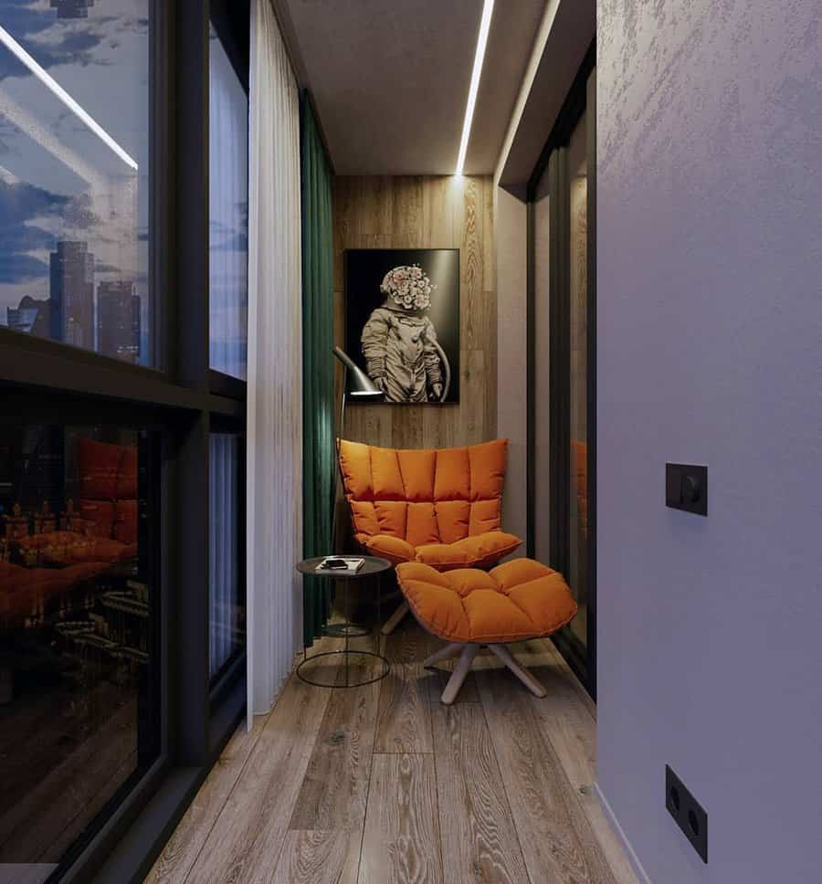 Modern balcony with an orange cushioned chair, round side table, and abstract artwork on the wall, cityscape is visible through windows