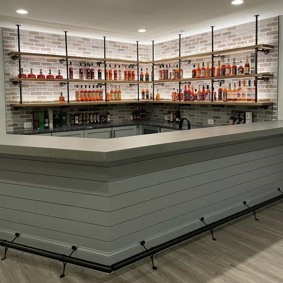 Modern basement bar with brick wall and shelves of bottles