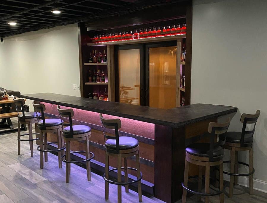 Wooden home bar with stools and purple accent lighting