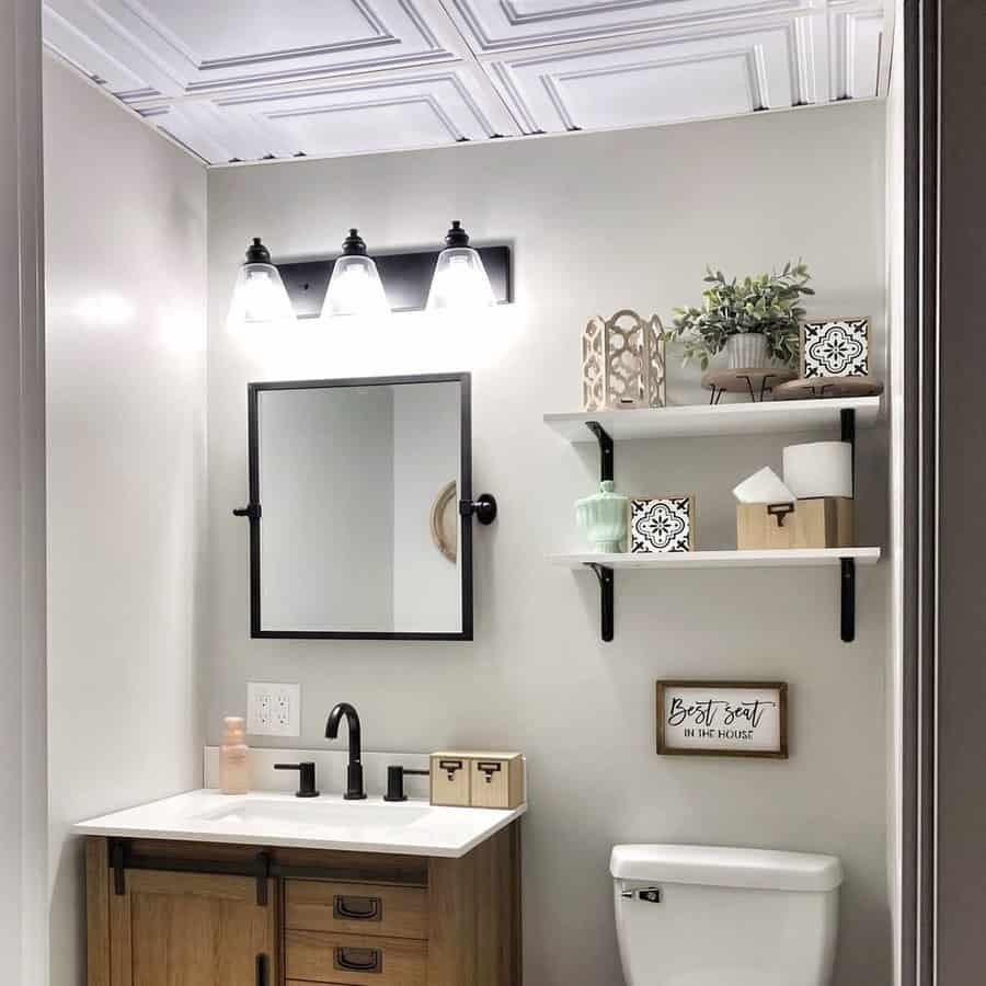 Modern bathroom with a white coffered ceiling, black accents, wooden vanity, and open shelving, creating a stylish and functional space.