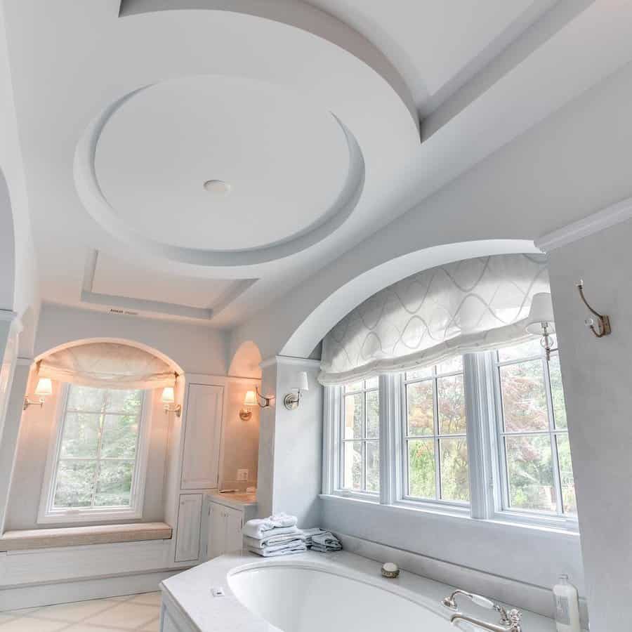 Luxury bathroom with an elegant circular tray ceiling, arched windows, and soft neutral tones, creating a serene and sophisticated retreat.